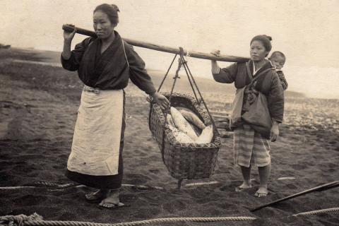 Two Japanese women carrying a basket of fish. The Thai for "two Japanese women carrying a basket of fish" is "ผู้หญิงญี่ปุ่นสองคนแบกตะกร้าปลา".