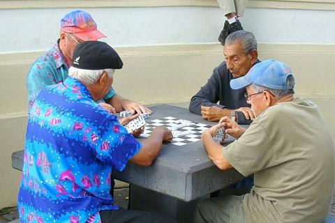 Four men playing dominoes. The Thai for "four men playing dominoes" is "ผู้ชายสี่คนกำลังเล่นโดมิโน".