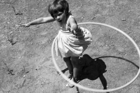 A girl twirling a hula hoop. The Thai for "a girl twirling a hula hoop" is "เด็กผู้หญิงหมุนฮูลาฮูป".
