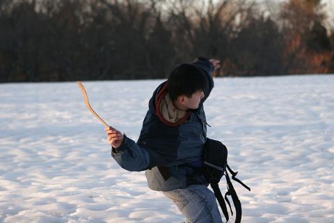 A man is throwing a boomerang on the snow.. The Thai for "A man is throwing a boomerang on the snow." is "ผู้ชายปาบูมเมอแรงบนพื้นหิมะ".