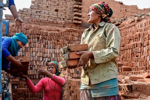 Female workers and a pile of bricks. The Thai for "female workers and a pile of bricks" is "คนงานหญิงและกองอิฐ".