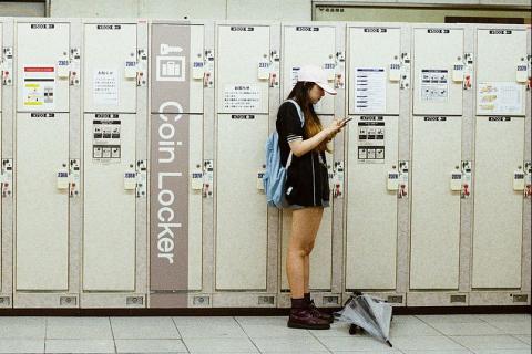 A woman in a white cap by some lockers. The Thai for "a woman in a white cap by some lockers" is "ผู้หญิงหมวกแก๊ปสีขาวที่ล็อกเกอร์".