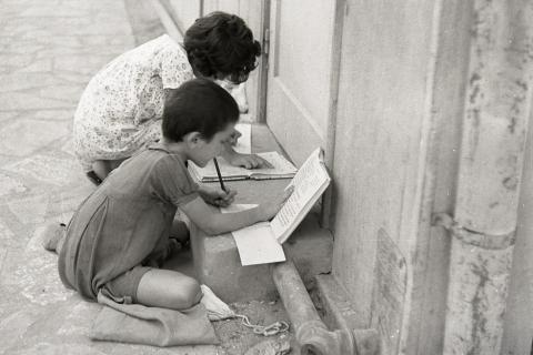 Two children doing homework. The Thai for "two children doing homework" is "เด็กสองคนทำการบ้าน".