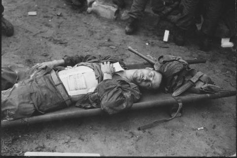 A wounded soldier on a stretcher. The Thai for "a wounded soldier on a stretcher" is "ทหารบาดเจ็บบนเปลหาม".