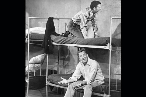 Two men on a bunk bed. The Thai for "two men on a bunk bed" is "ผู้ชายสองคนบนเตียงสองชั้น".