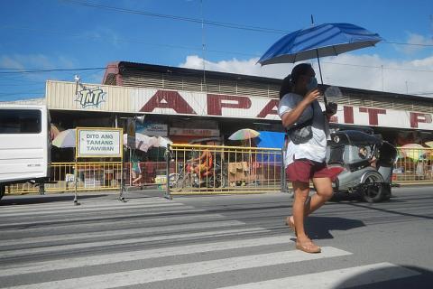 A woman with a blue umbrella crossing at a zebra crossing. The Thai for "a woman with a blue umbrella crossing at a zebra crossing" is "ผู้หญิงกับร่มสีน้ำเงินข้ามทางม้าลาย".