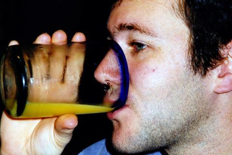 A man drinking orange juice. The Thai for "a man drinking orange juice" is "ผู้ชายดื่มน้ำส้ม".