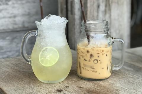 A jug of lemonade and a glass of iced coffee. The Thai for "a jug of lemonade and a glass of iced coffee" is "น้ำมะนาวหนึ่งเหยือกและกาแฟเย็นหนึ่งแก้ว".