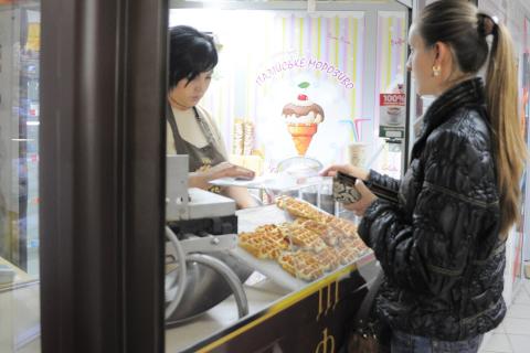 A woman buying waffles. The Thai for "a woman buying waffles" is "ผู้หญิงซื้อวาฟเฟิล".