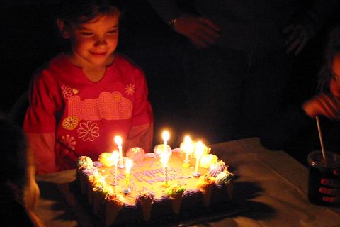 A girl making a wish on her birthday. The Thai for "a girl making a wish on her birthday" is "เด็กหญิงขอพรในวันเกิดของเธอ".