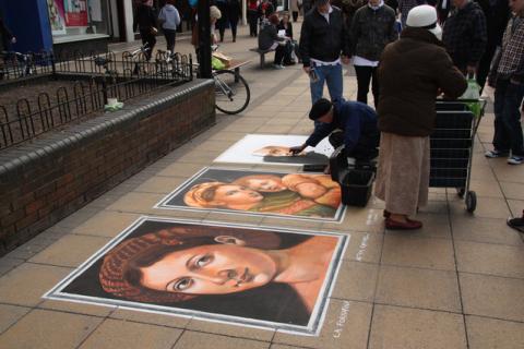 An artist painting on the sidewalk. The Thai for "an artist painting on the sidewalk" is "ศิลปินวาดรูปบนทางเท้า".