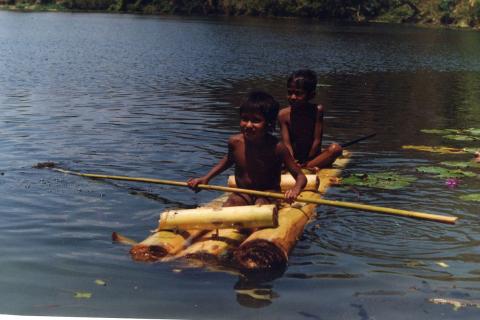 Two boys having fun on their raft. The Thai for "two boys having fun on their raft" is "เด็กผู้ชายสองคนสนุกบนแพของพวกเขา".