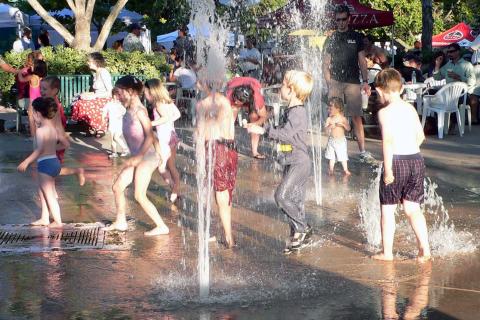 Kids playing in a fountain during a hot summer. The Thai for "kids playing in a fountain during a hot summer" is "เด็กๆเล่นน้ำพุในฤดูร้อน".