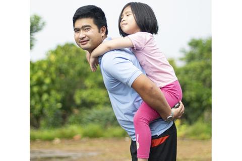 A girl having a piggyback ride on her father. The Thai for "a girl having a piggyback ride on her father" is "เด็กหญิงขี่หลังพ่อของเธอ".