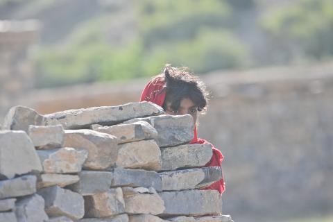 A girl hiding herself behind a wall. The Thai for "a girl hiding herself behind a wall" is "เด็กหญิงซ่อนตัวหลังกำแพง".