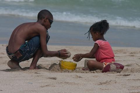 A boy with his sister on the beach. The Thai for "a boy with his sister on the beach" is "เด็กผู้ชายกับน้องสาวของเขาบนชายหาด".