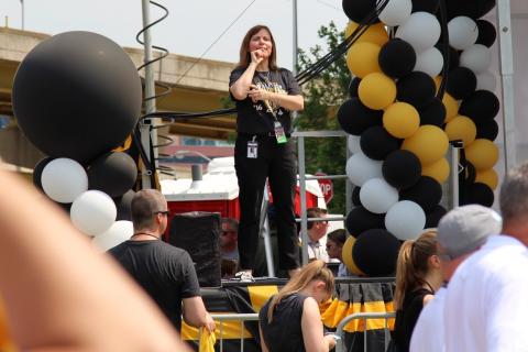 A sign language interpreter on a stage. The Thai for "a sign language interpreter on a stage" is "ล่ามภาษามือบนเวที".