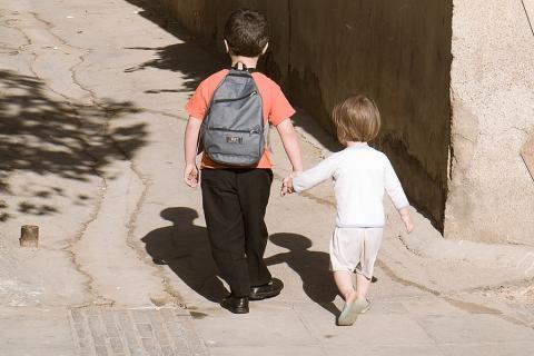A boy walking hand-in-hand with his younger brother. The Thai for "a boy walking hand-in-hand with his younger brother" is "เด็กผู้ชายจูงมือน้องชายของเขา".