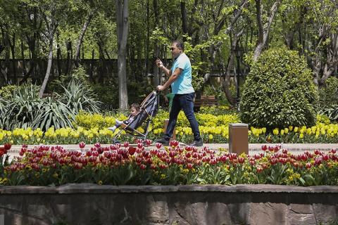 A man with his child in the park. The Thai for "a man with his child in the park" is "ผู้ชายกับลูกของเขาในสวนสาธารณะ".