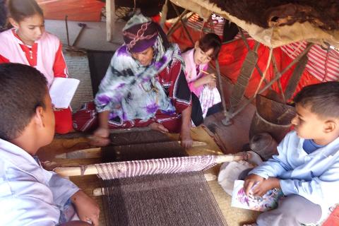 Children learning weaving. The Thai for "children learning weaving" is "เด็กๆเรียนรู้การทอผ้า".