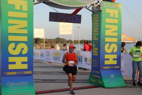 A female runner runs to the finish line. The Thai for "a female runner runs to the finish line" is "นักวิ่งหญิงวิ่งเข้าเส้นชัย".