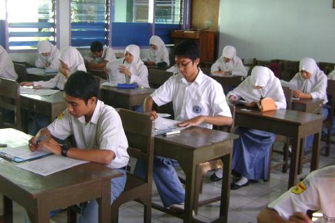 Students taking exams. The Thai for "students taking exams" is "นักเรียนกำลังสอบ".