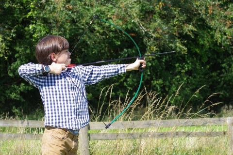 A boy shooting an arrow. The Thai for "a boy shooting an arrow" is "เด็กผู้ชายกำลังยิงธนู".