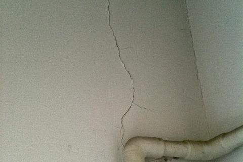 A cracked wall. The Thai for "a cracked wall" is "กำแพงร้าว".