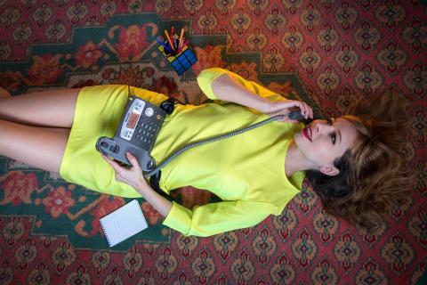 A woman lying on the carpet talking on the telephone. The Thai for "a woman lying on the carpet talking on the telephone" is "ผู้หญิงนอนคุยโทรศัพท์บนพรม".