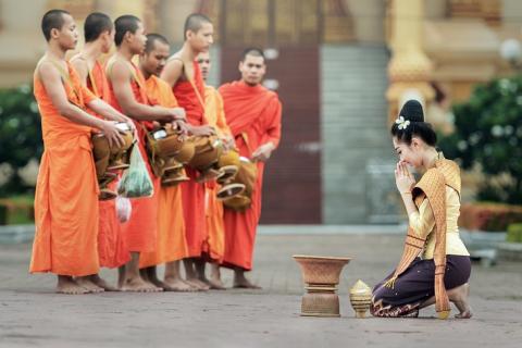 A Thai woman paying respect to monks. The Thai for "a Thai woman paying respect to monks" is "ผู้หญิงไทยไหว้พระ".