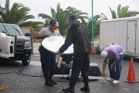 A team of technicians and a satellite dish. The Thai for "a team of technicians and a satellite dish" is "ทีมช่างและจานดาวเทียม".